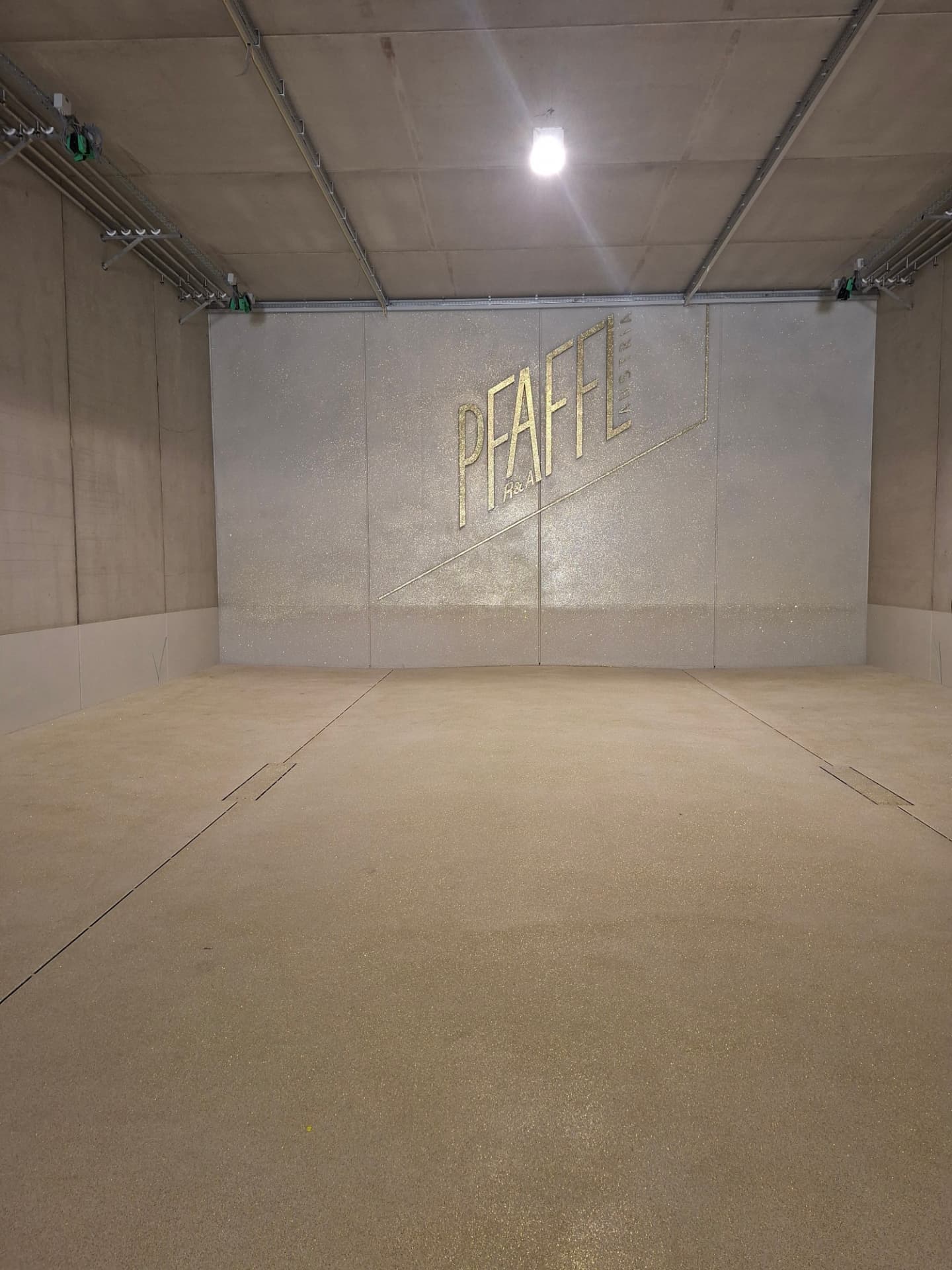 Weingut Pfaffl – Halle mit weiß-goldener Chips-Beschichtung auf Wand und Boden